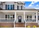 Close-up of a home's front porch with black door, white columns, brick stairs and black railings at 186 Gumtop Dr, Zebulon, NC 27597