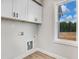 Well-lit laundry room featuring ample cabinet space, hookups, and a view at 186 Gumtop Dr, Zebulon, NC 27597