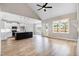 Open-concept living space with kitchen island, stainless appliances, modern ceiling fan, and hardwood floors at 186 Gumtop Dr, Zebulon, NC 27597