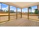 Enclosed porch featuring wood flooring, a ceiling, and black railings with views of the spacious backyard at 186 Gumtop Dr, Zebulon, NC 27597