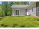 Lush green lawn with a patio, sliding glass door, and propane tank for outdoor relaxation and enjoyment at 205 Sacred Fire Rd, Louisburg, NC 27549