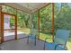 Covered and screened-in porch with chairs, overlooking wooded backyard at 205 Sacred Fire Rd, Louisburg, NC 27549