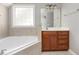Bright bathroom featuring a soaking tub and vanity with a neutral color palette at 2106 Cloud Cover Ln, Raleigh, NC 27614