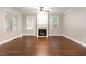 Inviting living room with a fireplace, large windows, and hardwood floors, perfect for relaxation and entertaining at 2106 Cloud Cover Ln, Raleigh, NC 27614