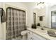 Well-lit bathroom featuring a shower with patterned curtain, vanity and modern fixtures at 2122 Pleasant Hill Rd, Rocky Mount, NC 27801