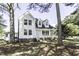 Beautiful two-story house featuring a welcoming porch, classic white siding and mature trees at 2122 Pleasant Hill Rd, Rocky Mount, NC 27801