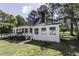 Exterior of a home with white siding, a manicured lawn, and mature trees at 2122 Pleasant Hill Rd, Rocky Mount, NC 27801