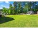 A spacious backyard with lush green grass and a charming shed offers a perfect outdoor retreat at 215 Terrell Dr, Rolesville, NC 27571