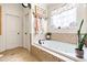 Bright bathroom featuring a large soaking tub with tile surround and decorative window at 215 Terrell Dr, Rolesville, NC 27571