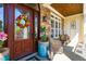 Welcoming front porch with stone accents, decorative door wreath, and cozy wicker seating for relaxing outdoors at 215 Terrell Dr, Rolesville, NC 27571