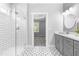 Bright bathroom with glass shower, double vanity, modern fixtures, and decorative tile floor at 238 W Paige Wynd Dr, Angier, NC 27501