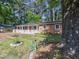 Charming brick home with a welcoming front porch and vibrant red door is nestled among mature trees at 2506 N Duke St, Durham, NC 27704