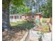 Charming brick home with a welcoming front porch and vibrant red door surrounded by flourishing garden beds at 2506 N Duke St, Durham, NC 27704