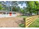 Quaint home with a welcoming front porch, a vibrant red door, and a charming wooden fence at 2506 N Duke St, Durham, NC 27704