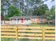 Inviting home with front porch, red door, solar panels and wooden fence, all framed by lush greenery at 2506 N Duke St, Durham, NC 27704