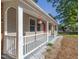 Charming front porch view showcasing a red door, white railing, and beautiful landscaping with white gravel at 2506 N Duke St, Durham, NC 27704