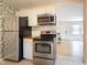 Kitchen with stainless appliances, white cabinets, wood counters, and citrus wallpaper at 2506 N Duke St, Durham, NC 27704