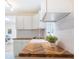 Bright kitchen featuring wood counters, white cabinets, subway tile backsplash and stainless faucet at 2506 N Duke St, Durham, NC 27704