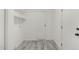 Bright laundry room with gray tile floor, shelving, and white cabinets at 2704 Dove Ln, Raleigh, NC 27604