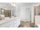 Bright bathroom featuring double sinks, white cabinets, and a large mirror at 2749 Nettles Ridge Way, Fuquay Varina, NC 27526