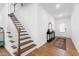 Inviting foyer featuring hardwood floors, staircase, console table with mirror, and access to the upper level at 2749 Nettles Ridge Way, Fuquay Varina, NC 27526