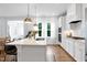 Modern kitchen with a large center island, stainless steel appliances, pendant lights, and white cabinetry at 2749 Nettles Ridge Way, Fuquay Varina, NC 27526