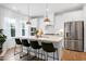 Modern kitchen featuring a spacious island with seating, stainless steel appliances, and elegant pendant lighting at 2749 Nettles Ridge Way, Fuquay Varina, NC 27526