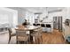 Open concept featuring kitchen island with bar stools, stainless appliances and adjacent dining area at 2749 Nettles Ridge Way, Fuquay Varina, NC 27526