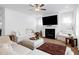 Bright living room featuring a fireplace, neutral decor, hardwood floors, and large windows with sheer curtains at 2749 Nettles Ridge Way, Fuquay Varina, NC 27526