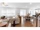 Open-concept living space featuring hardwood floors, a fireplace, a cozy seating area, and a dining area at 2749 Nettles Ridge Way, Fuquay Varina, NC 27526