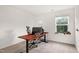 Bright, comfortable office featuring an adjustable desk, comfortable chair, and natural light from the window at 2749 Nettles Ridge Way, Fuquay Varina, NC 27526