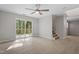 Bright living room with sliding glass door to deck, neutral walls, and stairs to basement at 2806 Shaftsbury St, Durham, NC 27704