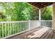 Private balcony with wooden floor and white railing surrounded by lush trees at 2810 Bedford Green Dr # 207, Raleigh, NC 27604