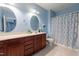 Bathroom with double sinks and a vanity with dark wood cabinets and a shower tub combo at 2810 Bedford Green Dr # 207, Raleigh, NC 27604