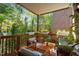Charming covered back deck with wooden furniture, lush greenery, and brick exterior at 3009 Weston Green Loop, Cary, NC 27513