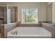 Bathroom with a soaking tub, tile accents, and a window providing natural light at 3009 Weston Green Loop, Cary, NC 27513