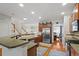 Well-lit kitchen featuring granite countertops, stainless appliances, an open floor plan, and hardwood floors at 3009 Weston Green Loop, Cary, NC 27513