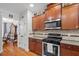 Well-lit kitchen featuring dark wood cabinets, granite countertops, and stainless appliances at 3009 Weston Green Loop, Cary, NC 27513