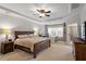 Spacious main bedroom featuring tray ceilings, a cozy bed, and an adjacent office space at 3009 Weston Green Loop, Cary, NC 27513