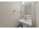 Half bathroom featuring a pedestal sink, modern mirror, and stylish fixtures at 311 Arlington Rdg, Cary, NC 27513