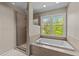 Bathroom featuring a shower and tub with decorative tile and a view of the outside at 311 Arlington Rdg, Cary, NC 27513
