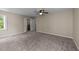 Neutral bedroom featuring a ceiling fan, carpet, and double doors leading to an en-suite bath at 311 Arlington Rdg, Cary, NC 27513