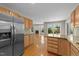 Open concept kitchen with stainless steel refrigerator, granite countertops, and view into living room at 311 Arlington Rdg, Cary, NC 27513