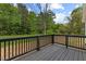 Wooden deck with dark wood railing, offering a view of the surrounding greenery at 326 W Gilbreath St, Graham, NC 27253