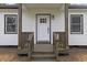 Welcoming front porch with dark stained wood railings, steps, and support pillars at 326 W Gilbreath St, Graham, NC 27253