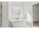 A modern bathroom featuring a freestanding tub under a window and marble floors at 3297 Oakfields Rd # 1, New Hill, NC 27562