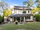 A spacious backyard featuring a covered patio, stone fireplace, and lush lawn ideal for outdoor entertainment at 3316 Milton Rd, Raleigh, NC 27609