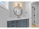 Bathroom vanity with blue cabinets, white countertop and round mirror at 3316 Milton Rd, Raleigh, NC 27609