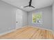 Neutral bedroom with ceiling fan, light hardwood floors and a bright window at 3316 Milton Rd, Raleigh, NC 27609