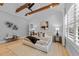 Bright main bedroom with tray ceiling, exposed wood beams, accent wall and large windows at 3316 Milton Rd, Raleigh, NC 27609